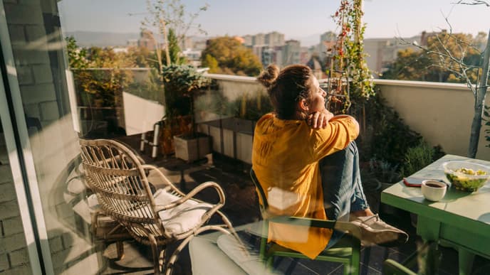 Junge Frau auf dem Balkon im Frühling 