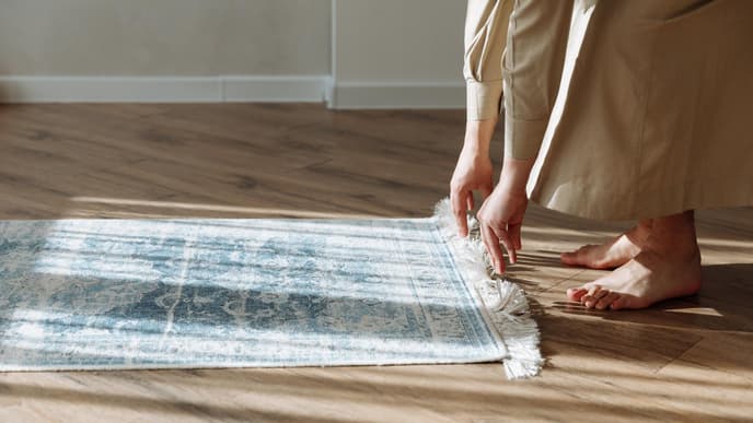 Person rollt Teppich aus