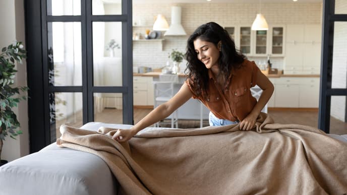 Frau mit Decke im Wohnzimmer