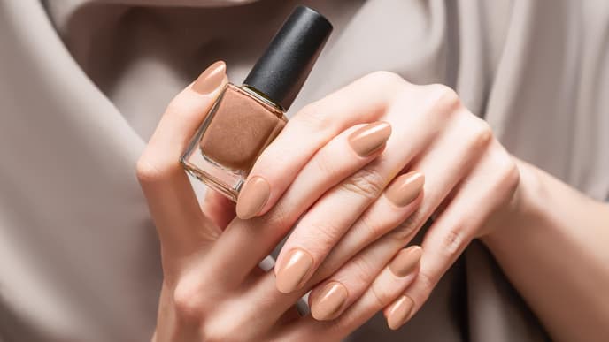 Person hält braunen Nagellack