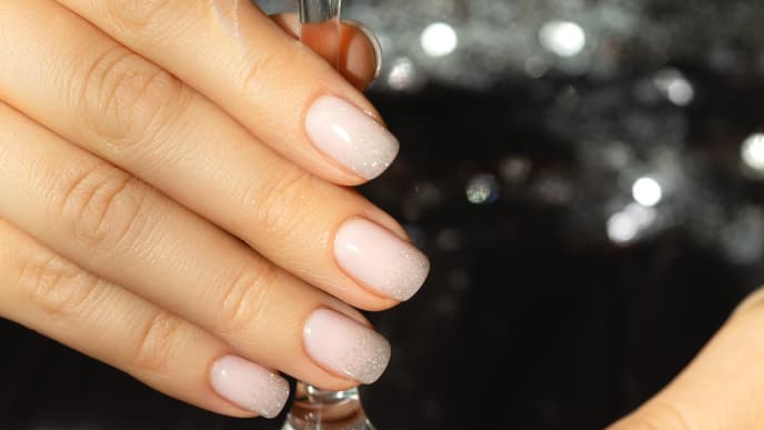 Frau trägt Nude-Nagellack 