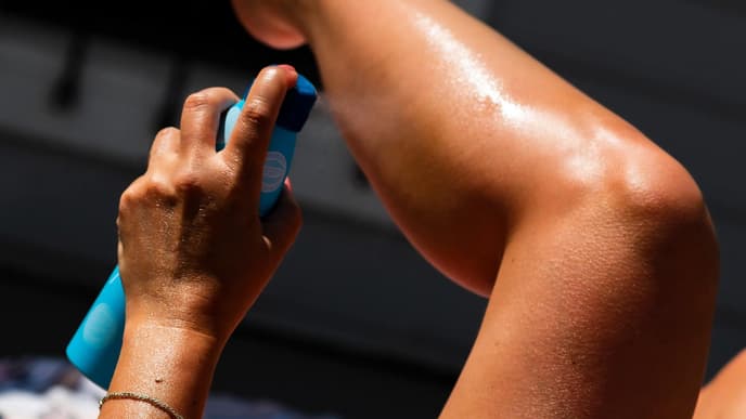 Frau trägt Sonnencreme auf