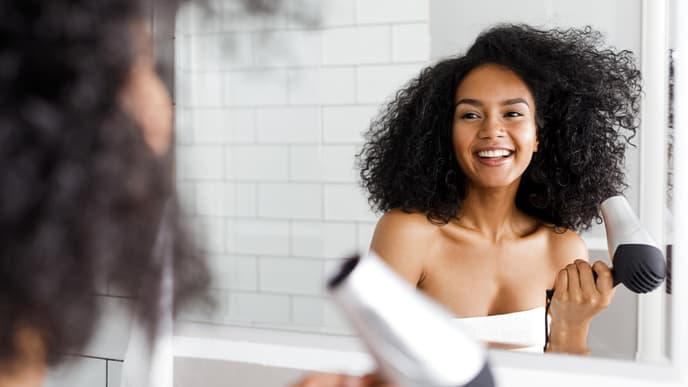 Frau föhnt Haare