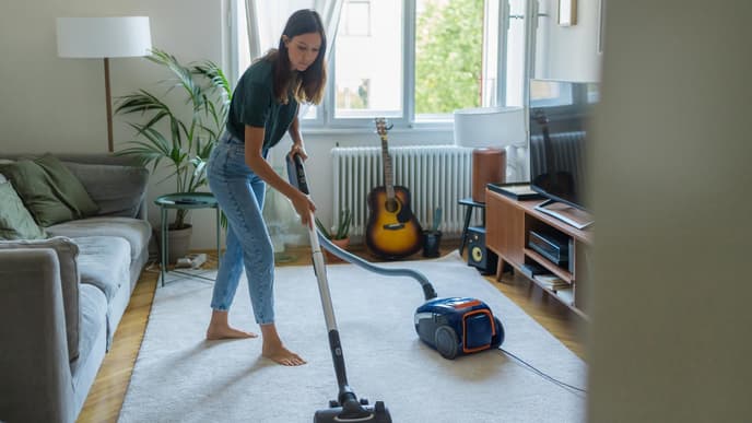 Frau saugt das Wohnzimmer