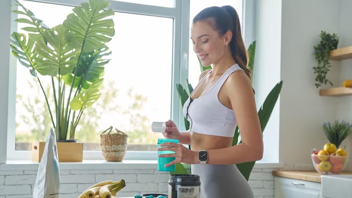 Frau mixt sich Shake nach Sport