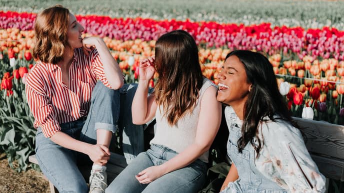 Frauen lachen auf Parkbank