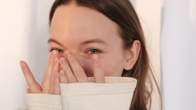 Lachen als Schutzmechanismus: Frau verdeckt ihr lachen
