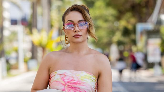 Eine Frau trägt ein Bandeau-Kleid und eine Sonnenbrille