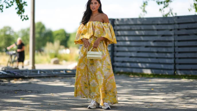 Frau im floralen Maxi-Kleid mit Sneakern