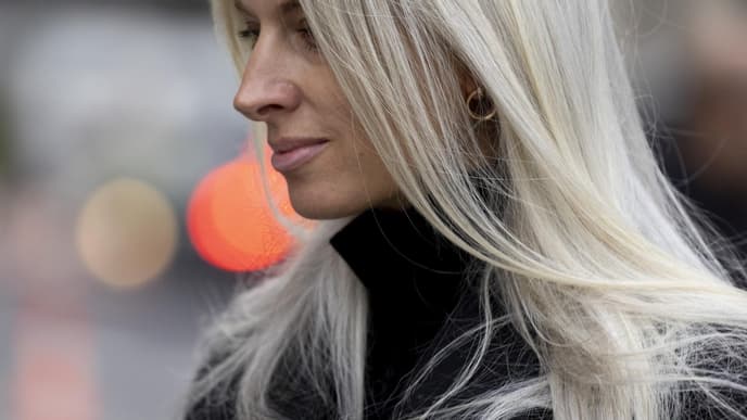 Frau trägt schwarzen Mantel und graue Haare mit Fox Cut