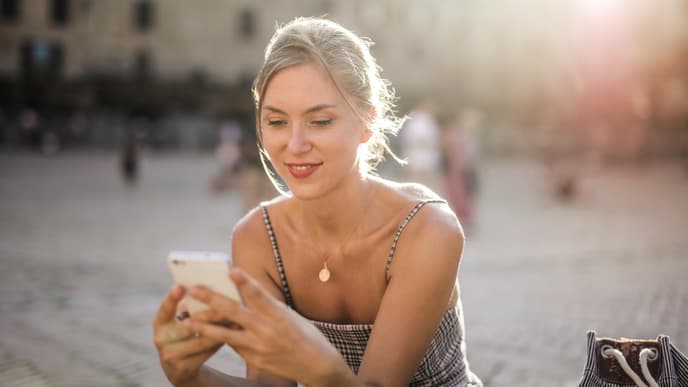 Junge Frau schaut auf Smartphone