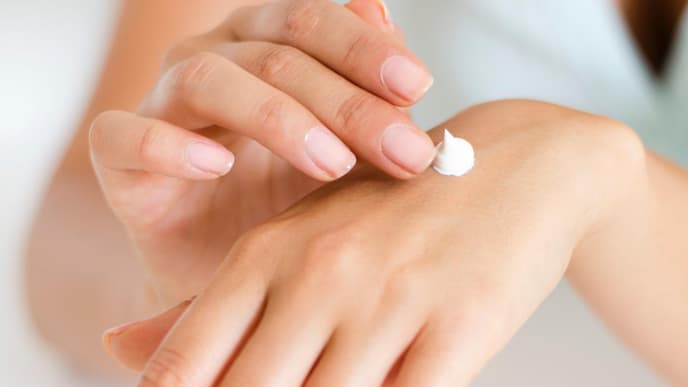 Frau trägt sich Creme auf Hand auf Handcreme Bodylotion