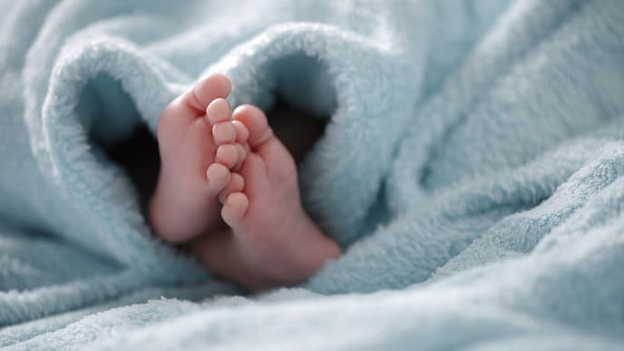 Babyfüße unter einer hellblauen Decke