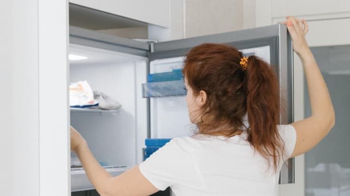 Frau öffnet Gefriertruhe