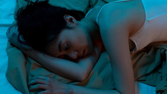 Traurige Frau liegt im Bett