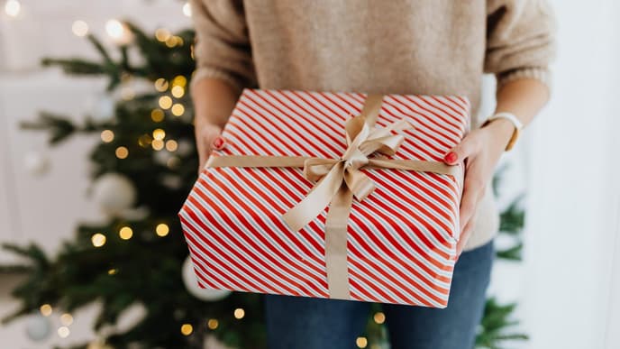 Person mit Geschenk in der Hand