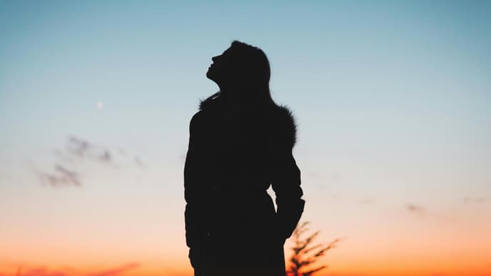 Silhouette einer Frau beim Sonnenaufgang