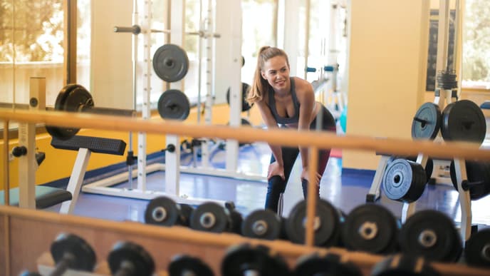 Frau im Fitnessstudio mit Hanteln