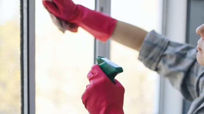 Frau putzt Fenster