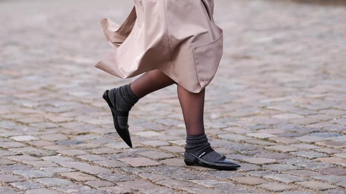 Frau trägt schwarze Sling-Ballerinas