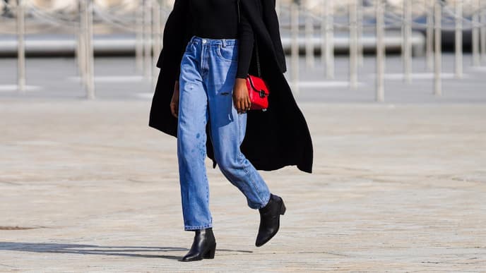 Frau trägt rote Tasche und Jeans