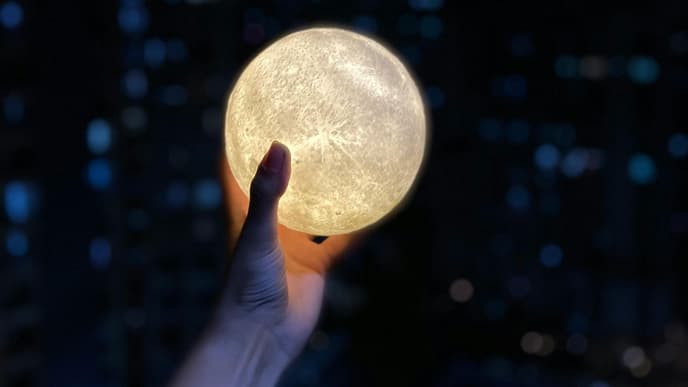 Hand hält eine Lichterkugel