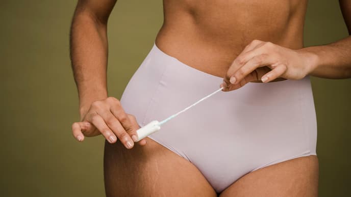 Frau mit Periodenunterwäsche und Tampon in der Hand