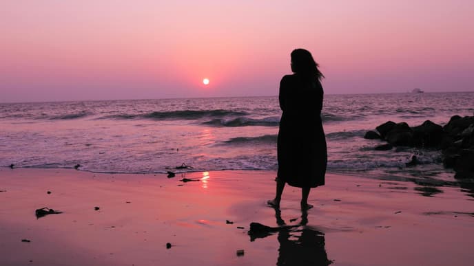 Silhouette einer Frau am Meer
