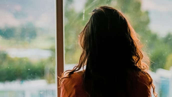 Frau schaut aus dem Fenster