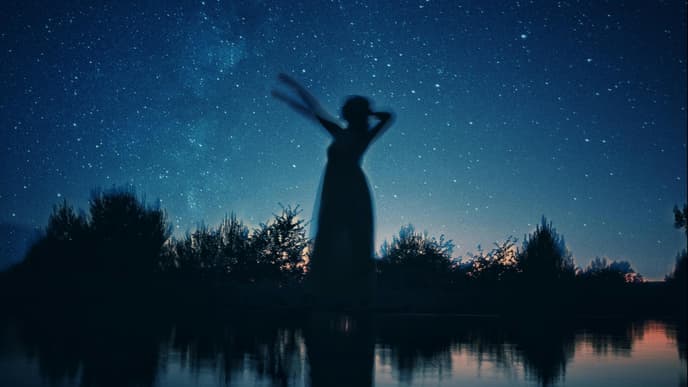 Silhouette einer Frau vor Sternenhimmel