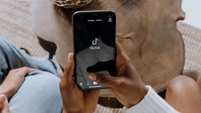 Frau hält Handy mit der TikTok App