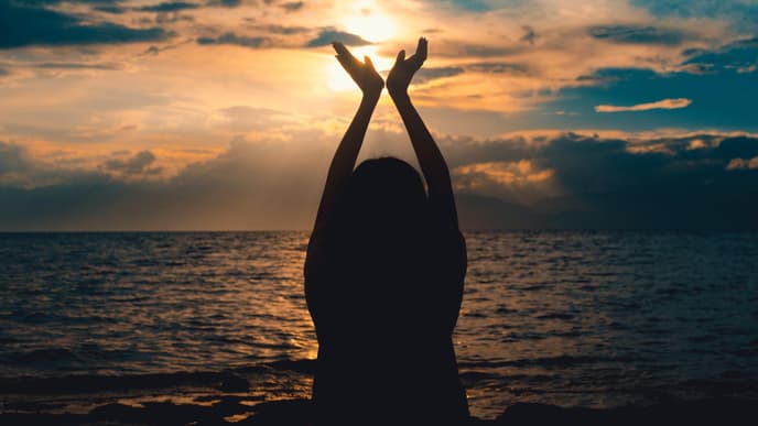 Silhouette einer Frau am Strand mit dem Meer im Hintergrund