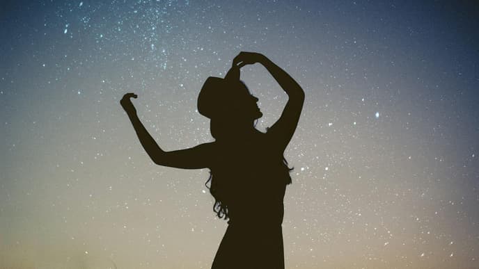 Frau tanzt unterm Sternenhimmel