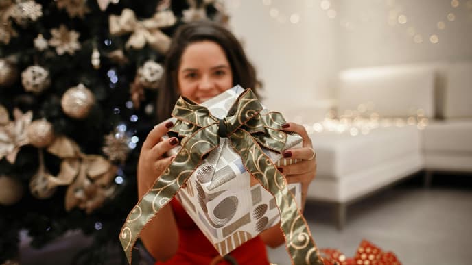 Frau mit Weihnachtsgeschenk in der Hand