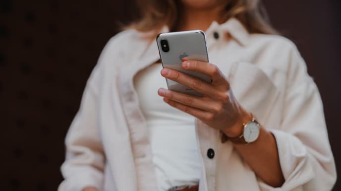 Eine Frau hält ein iPhone in der Hand
