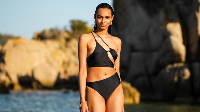 Eine Frau am Strand in einem schwarzen Bikini