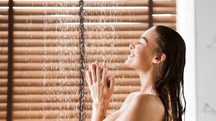 Eine Frau steht unter der Dusche