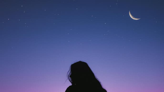 Frau steht vor Sternenhimmel