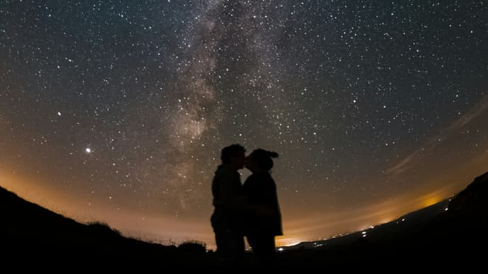 Paar küsst sich unter Sternenhimmel