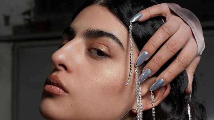 Frau mit silbernen Fingernägeln und Ketten