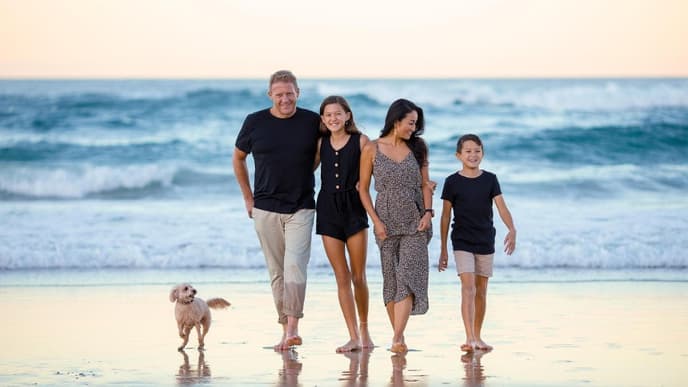 Eine Familie läuft am Strand entlang