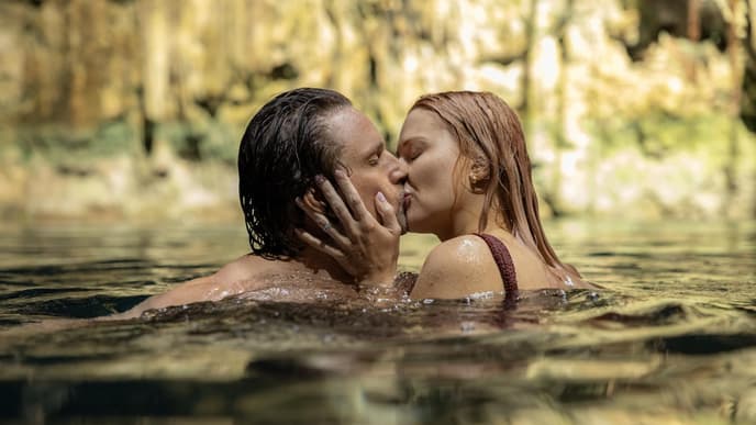 Ein Mann und eine Frau schwimmen im Wasser und küssen sich.
