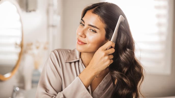 Frau kämmt ihre Haare