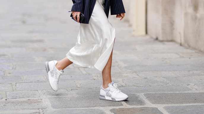 Eine Frau trägt helle Sneaker