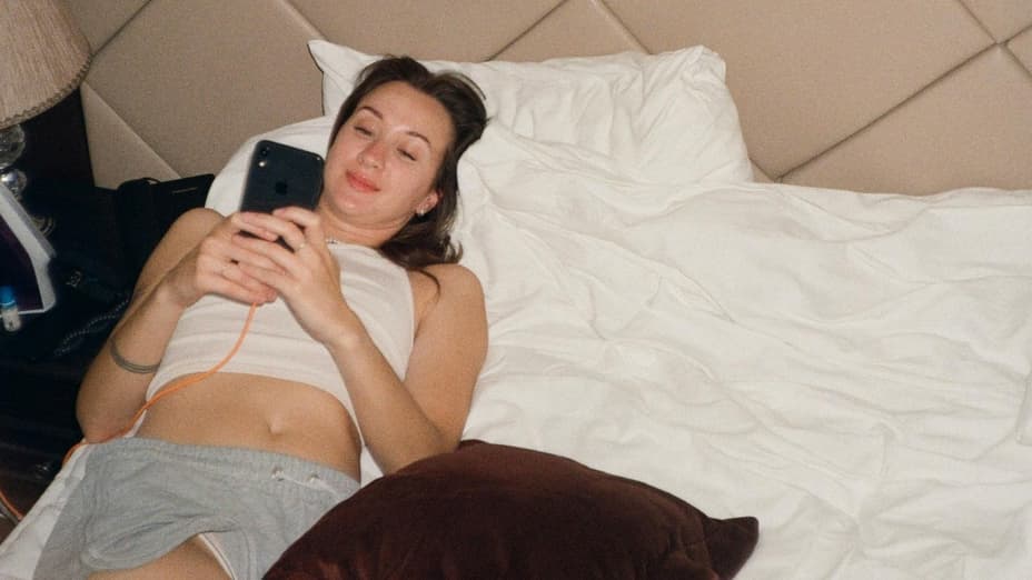 Frau im Bett verschickt Sex-Nachrichten