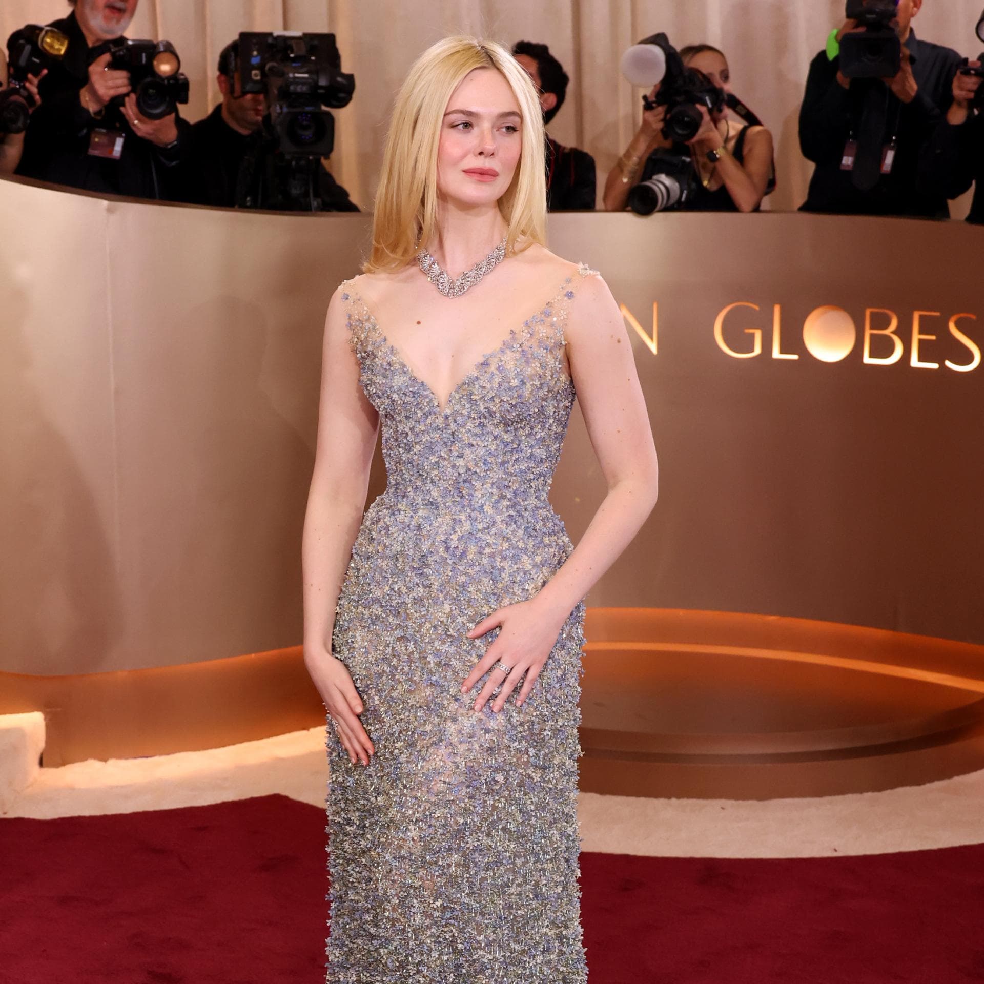 Elle Fanning in einem bodenlangen, silberglitzernden Kleid.
