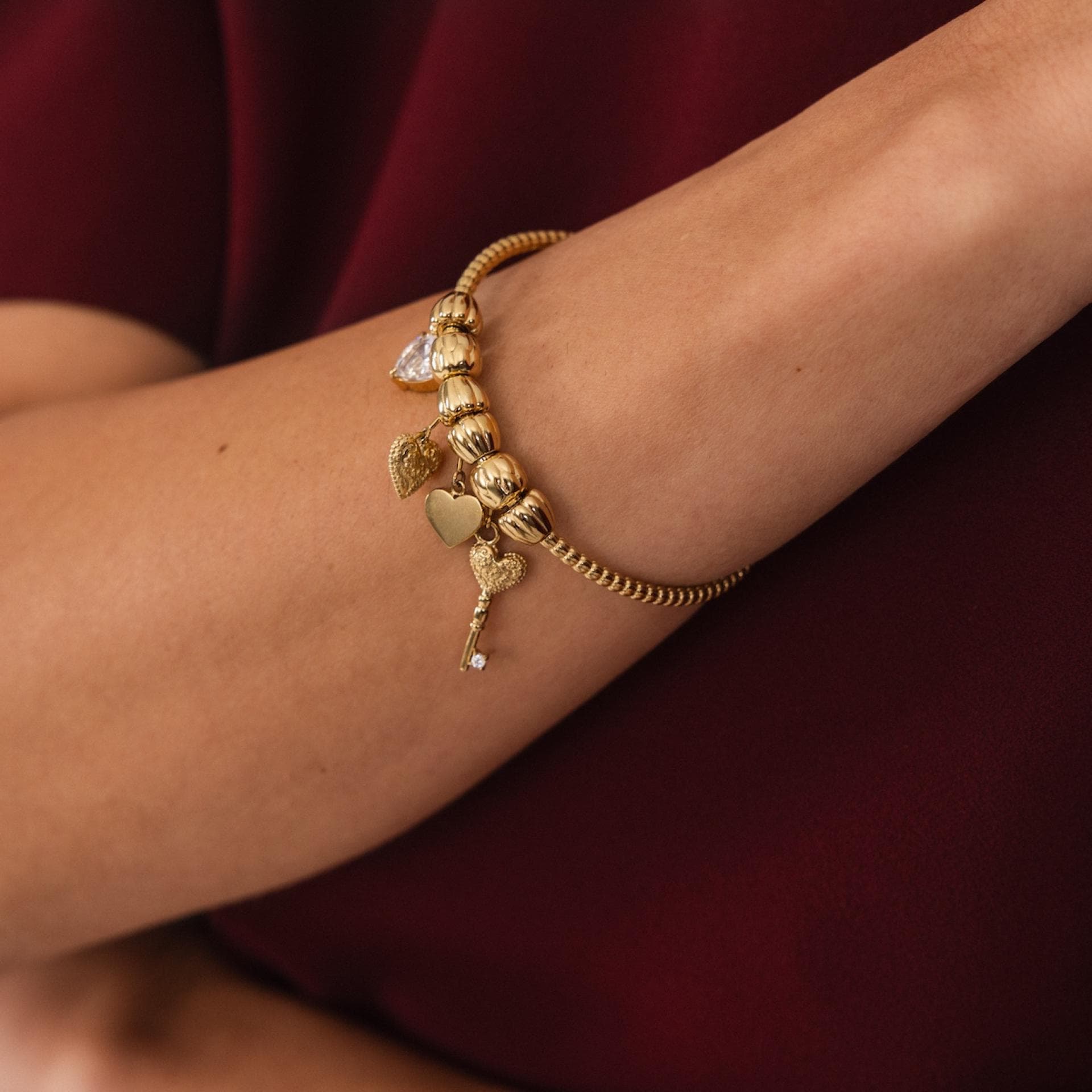 Frau mit einem goldenen Armband mit Charms.