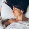 Frau liegt im Bett und schläft