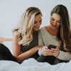 Zwei Frauen gucken auf ihr Handy