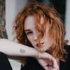 Frau mit Tattoo am handgelenk